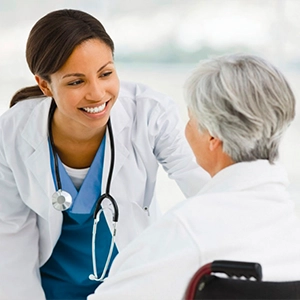 Healthcare professional speaking warmly with an older adult about wellness routines